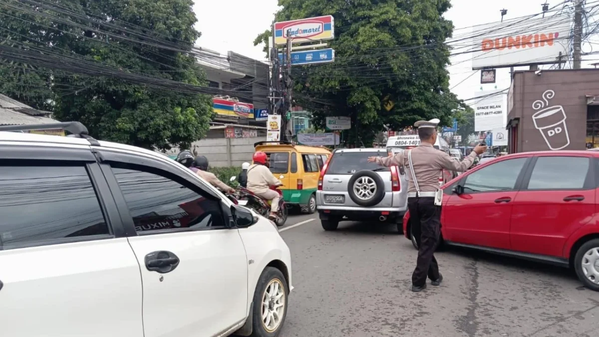 MENGATUR: Salah satu petugas Polsek Jatinangor saat menertibkan lalulintas di wilayah Jatinangor, baru-baru in