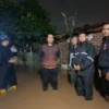 TANGANI: Kepala Desa Sindanggalih Eddy Setiawan saat meninjau titik lokasi banjir, Minggu (1/12) malam.