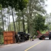 LAKA LANTAS: Sejumlah petugas saat mengevakuasi truk terguling di Jalan Cadas Pangeran, kemarin.