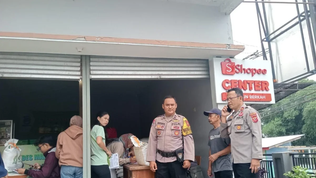 BERSINERGI: Kapolsek Cimanggung, Kompol D Karyaman (kanan) saat memantau pendistribusian beras Bulog di Desa M