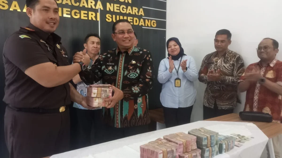 KEMBALIKAN: Kajari Sumedang, Ade Purnama saat menyerahkan uang kelebihan kepada Pj Bupati Sumedang Yudia Ramli