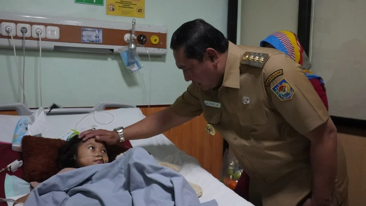 PRIHATIN: Pj Yudia Ramli saat menjenguk Devina (10) yang sedang dirawat di Rumah Sakit Umar Wirahadikusumah, b