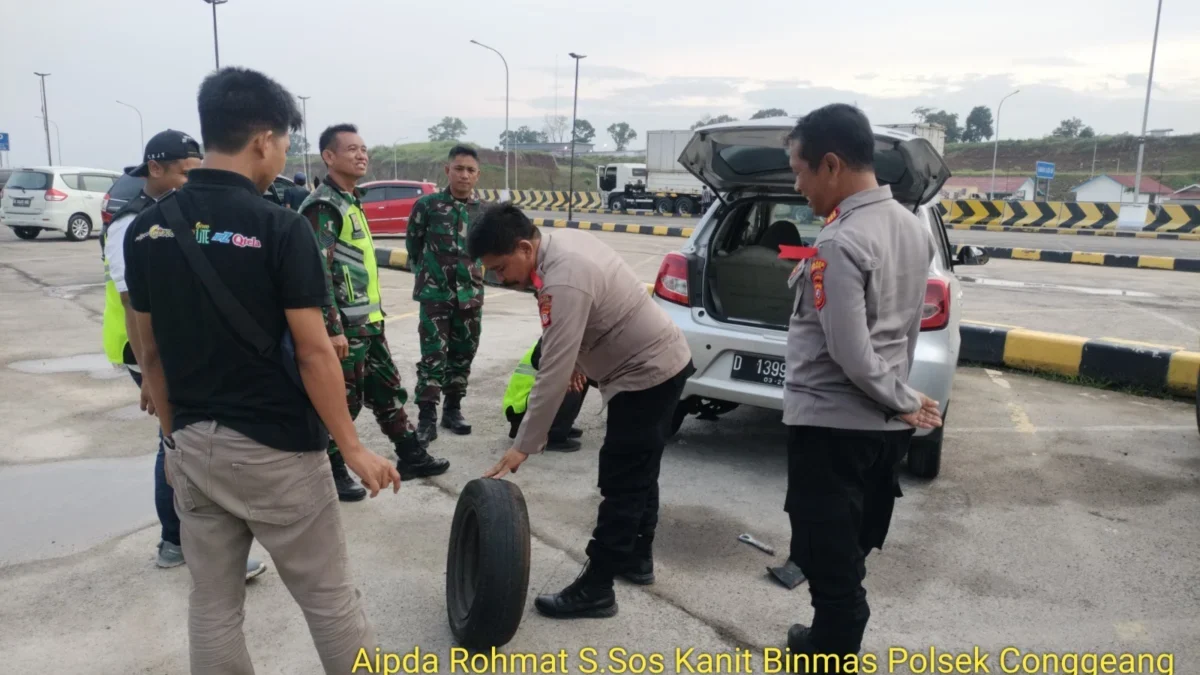 SINERGI: Ka Pos Pelayanan, AKP Suratman sigap membantu pengendara yang mengalami pecah ban, baru-baru ini.