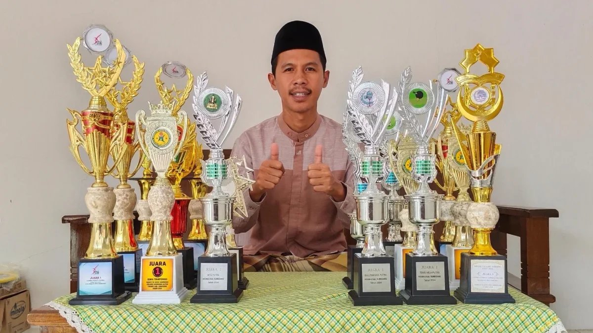 BERPRESTASI: Kepala MA Plus Al Hikam, Ayi Abdul Kohar, saat menunjukan trofi yang di raih sekolahnya, baru-bar