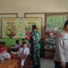 PANTAU: Bhabinkamtibmas Desa Cikeruh Polsek Jatinangor, Aiptu Ayi Aan saat monitoring pelaksanaan makan siang