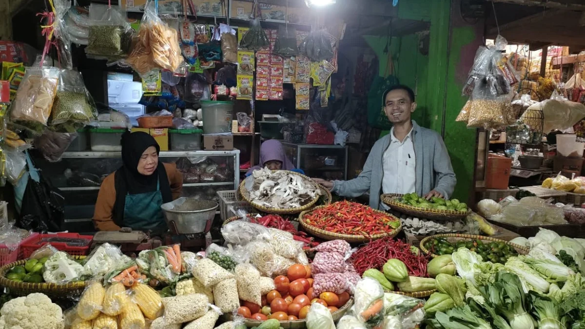 STABIL: Petugas pencatat harga pasar, Cepy saat mengecek harga kebutuhan pokok di Pasar Tanjungsari, kemarin.