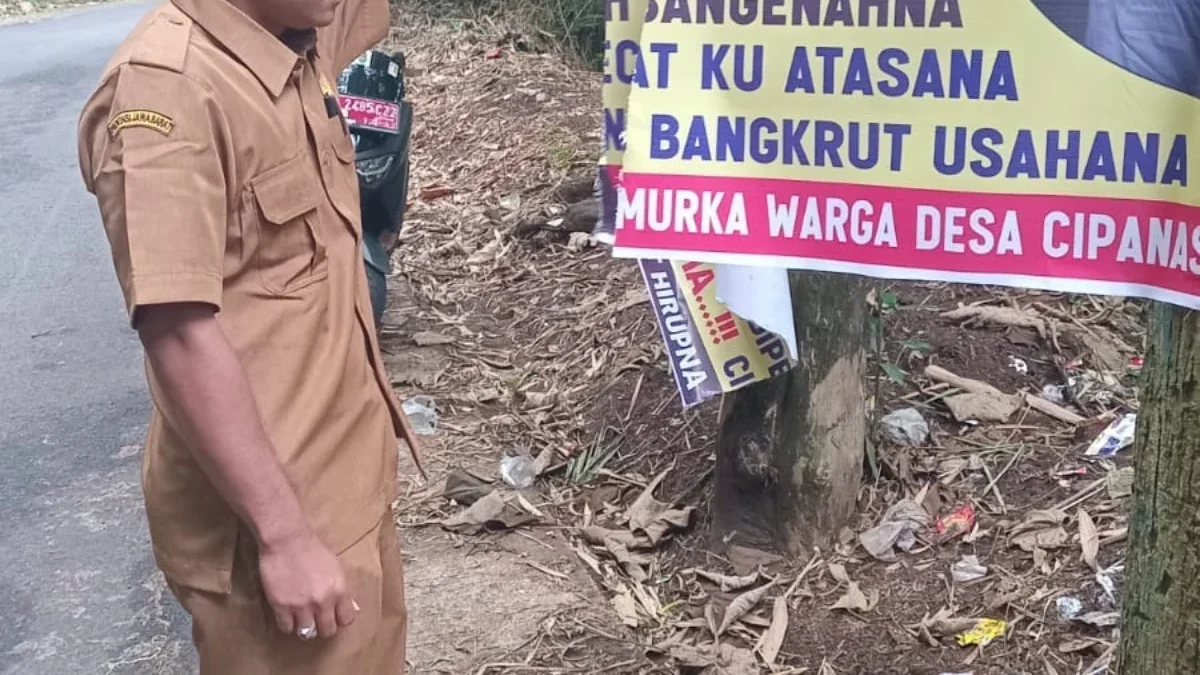 GERAM: Sekretaris Desa Cipanas Kecamatan Tanjungkerta, Deni Ramdhani saat mengecek baligo yang dirusak oknum t