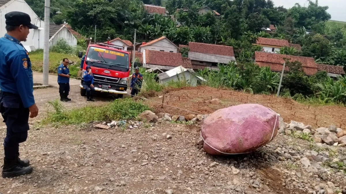 AMANKAN: Petugas Damkar saat menggeser batu besar dengan menggunakan tarikan mobil Damkar di Desa Mulyasari, k