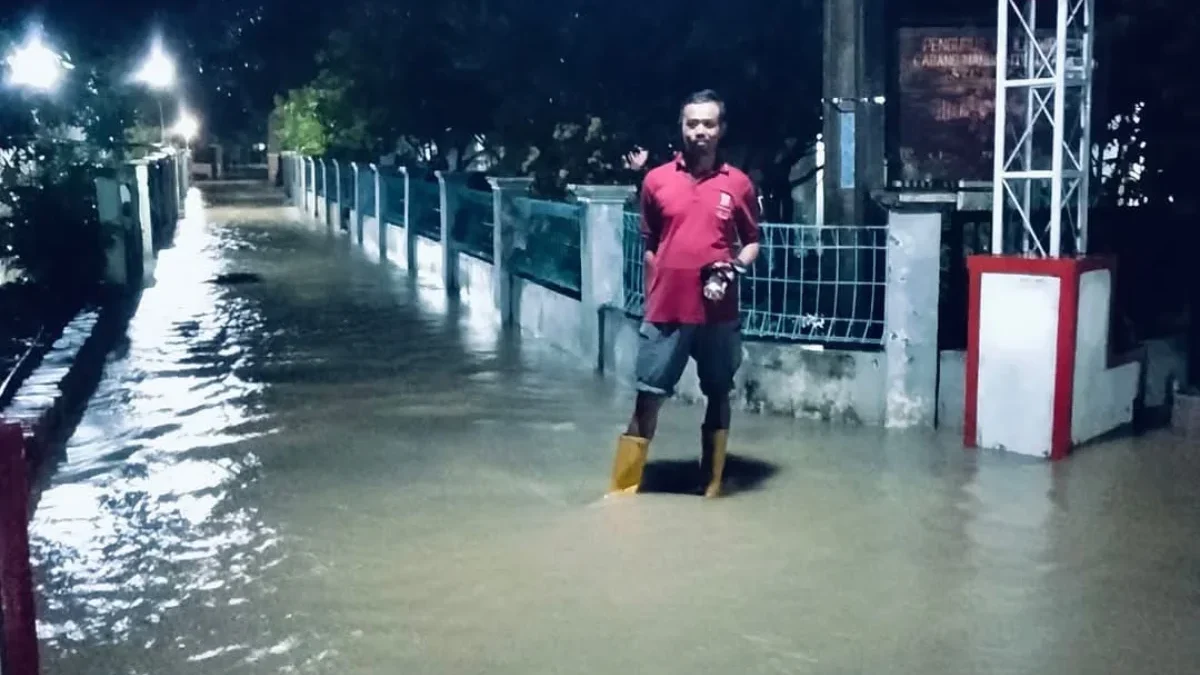 BANJIR: Seorang warga saat memantau banjir di wilayah Dusun Borojol Desa Sukamulya Kecamatan Ujungjaya.