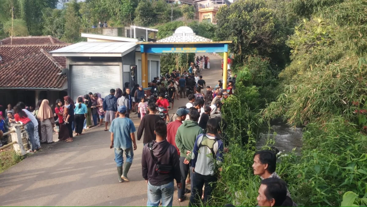 Warga berkerumun di lokasi kejadian kecelakaan pengendara motor masuk sungai Citarik Desa Sindulang Sumedang