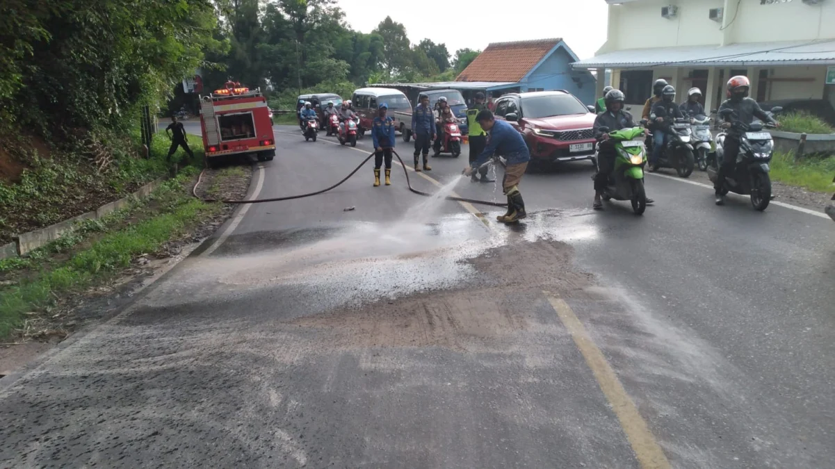 Tumpahan Solar di Jatinangor Celakai Tiga Pemotor LICIN: Petugas UPT Damkar Tanjungsari saat membersihkan solar yang tumpah di Jalan Bandung-Cirebon Kecamatan J