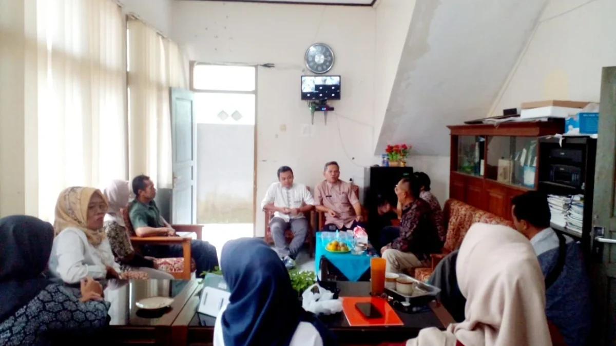 KOORDINASI: Plt Camat Sumedang Utara Ili, S.Sos., (tengah) bersama tim pendamping, saat kegiatan sosialisasi a