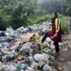 TUNJUKKAN: Salah seorang warga saat menunjukkan tumpukan sampah yang menimbulkan bau tidak sedap di Kecamatan