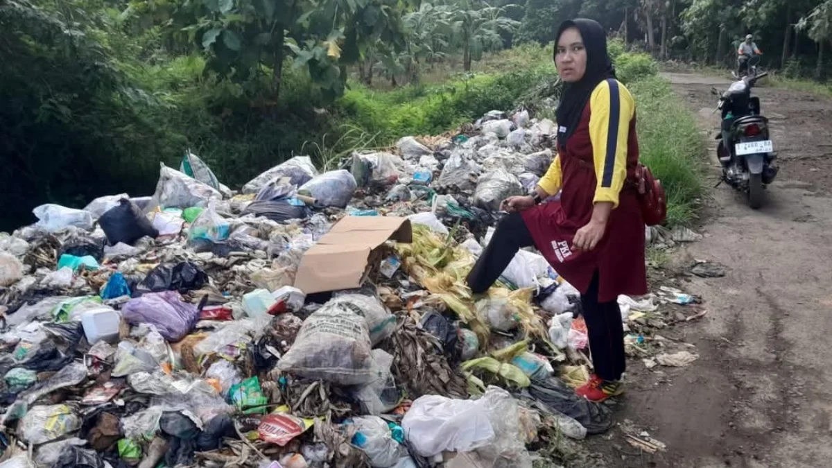 TUNJUKKAN: Salah seorang warga saat menunjukkan tumpukan sampah yang menimbulkan bau tidak sedap di Kecamatan