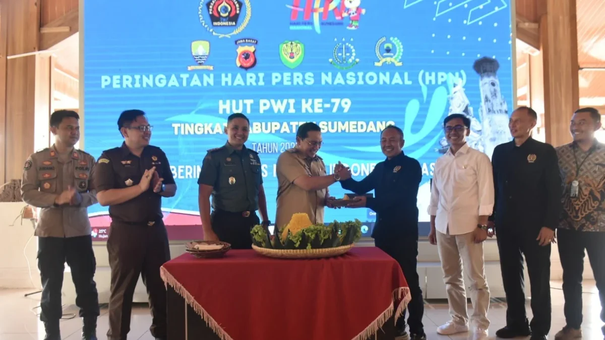 BERSINERGI: Pj Bupati Sumedang Yudia Ramli saat memberikan potongan tumpeng kepada Ketua PWI Sumedang Ade Hade