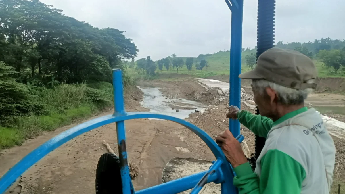 TUNJUKKAN: Seorang petani di Kecamatan Ujungjaya menunjukkan Bendung Sementara Cariang yang jebol, Selasa (11/