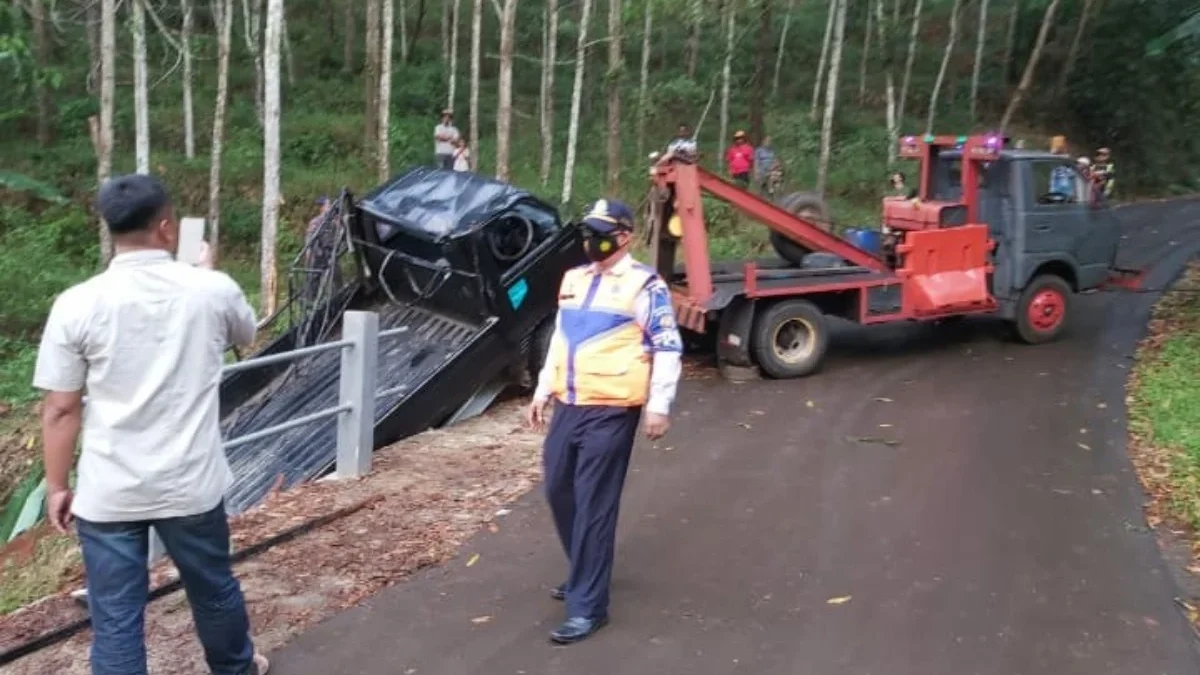 LAKA LANTAS: Petugas saat mengevakuasi sebuah mobil yang kecelakaan akibat jalan menuju Buricak Burinong yang