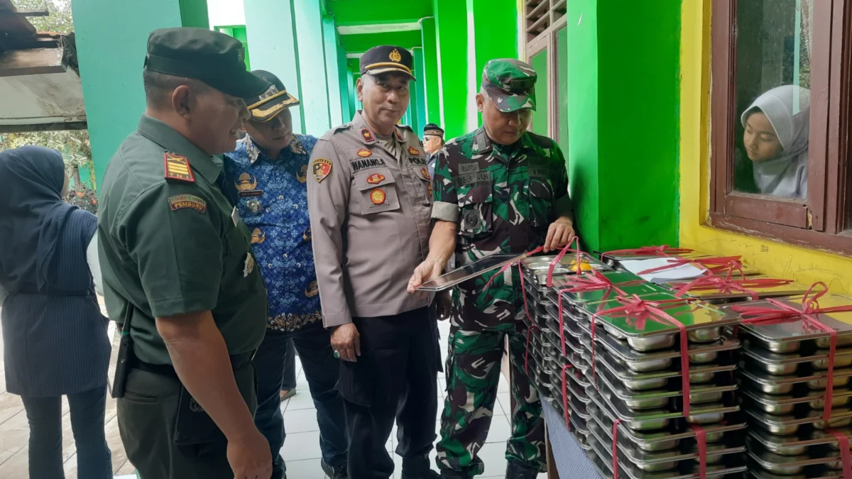 BAGIKAN: Sejumlah aparat saat SPPG dalam rangka program Makan Bergizi Gratis di SDN Gudang 1, kemarin.