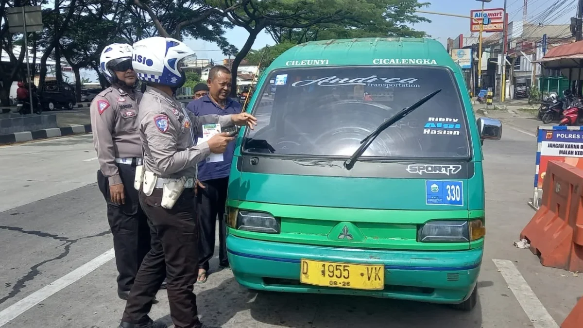 TERTIBKAN: Petugas Polsek Cimanggung saat menyosialisasikan keselamatan berlalu lintas, kemarin.