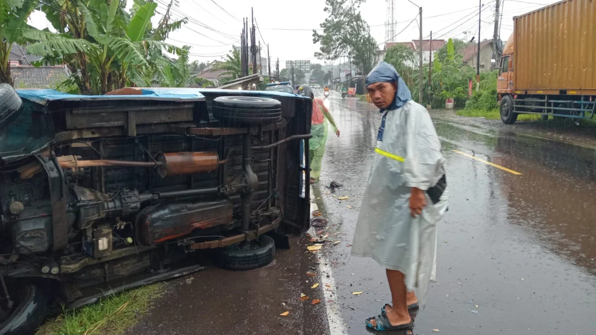 KECELAKAAN: Seorang warga saat melakukan evakuasi mobil angkot 02 di Dusun Babakanbuah RT 003 RW 001 Desa Lego