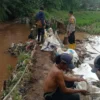 MELUAP: Sejumlah warga saat berupaya memperbaiki tanggul yang jebol di Kecamatan Cimanggung, baru-baru ini.