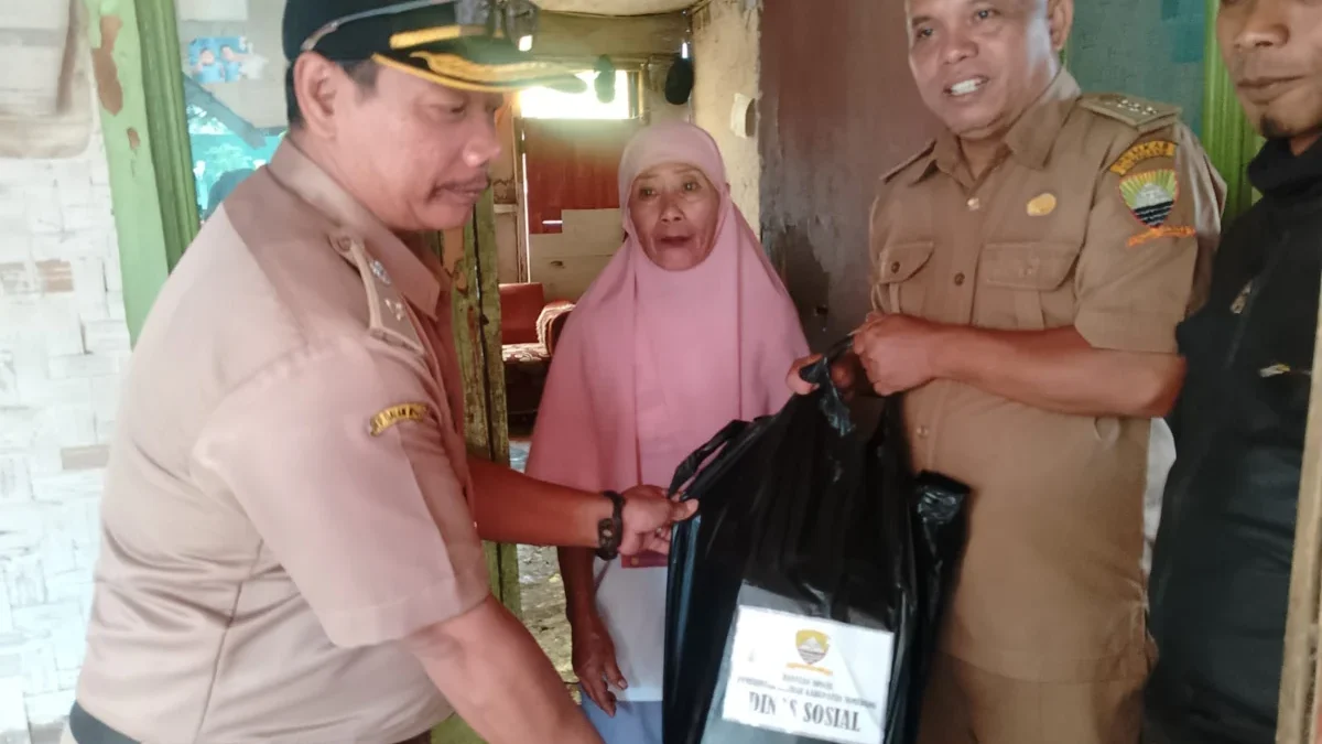 BANTU WARGA: Camat Cimanggung, Agus Wahyudin bersama aparat setempat saat memberikan bantuan sosial kepada Pop
