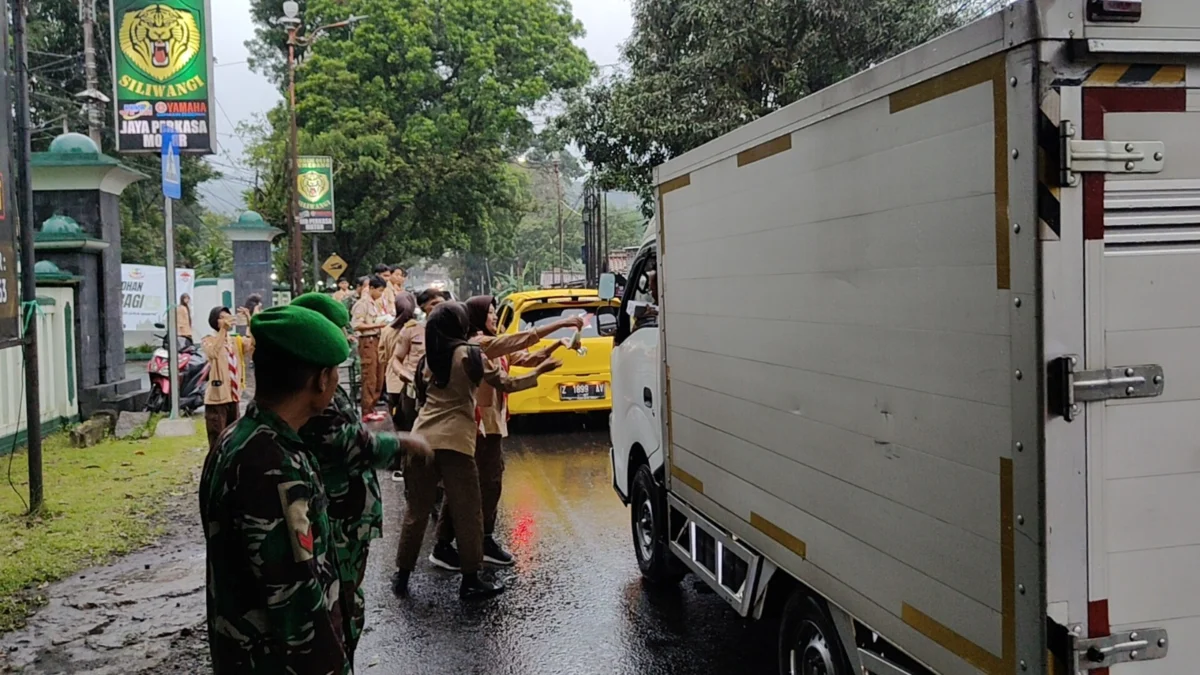 PEDULI: Anggota Pramuka Saka Wira Kartika membagikan takjil kepada pejalan kaki dan pengguna kendaraan di depa