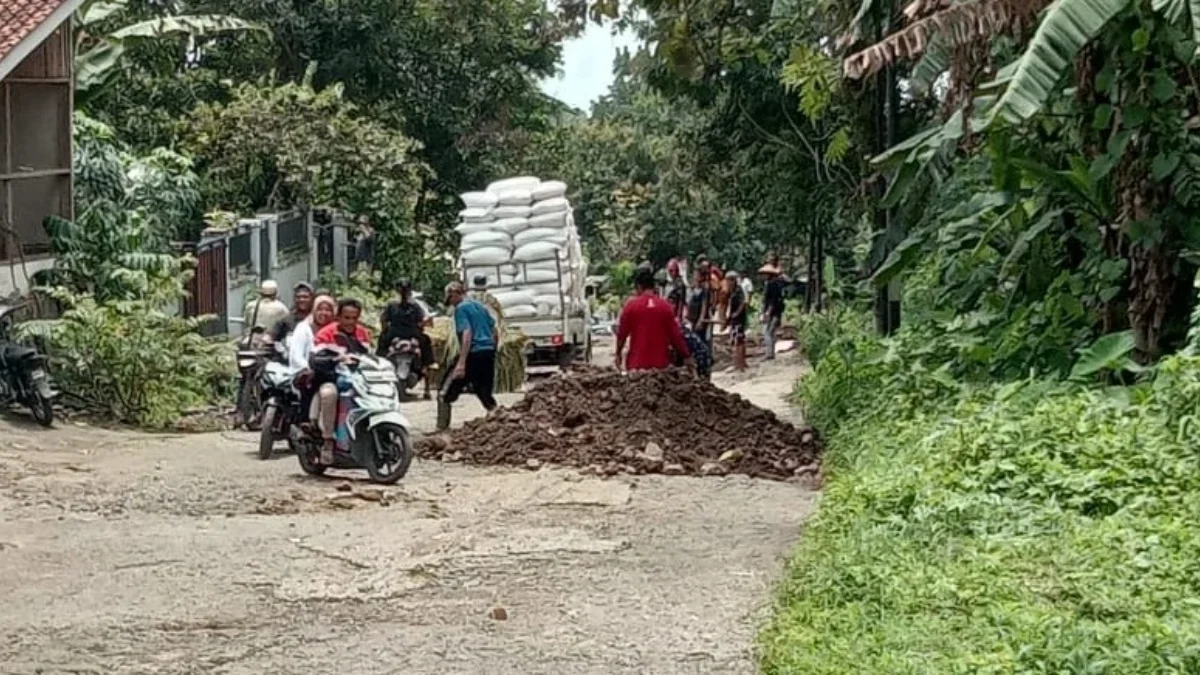 BENAHI: Beberapa warga saat bergotong-royong memperbaiki jalan Ujungjaya-Conggeang yang mengalami rusak parah