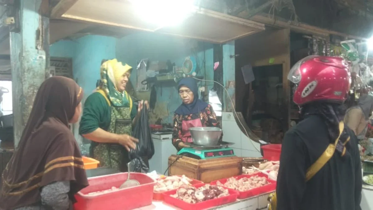 MELONJAK: Salah satu pedagang daging ayam, Hera, saat melayani pembeli di Pasar Sumedang, Senin (17/3).