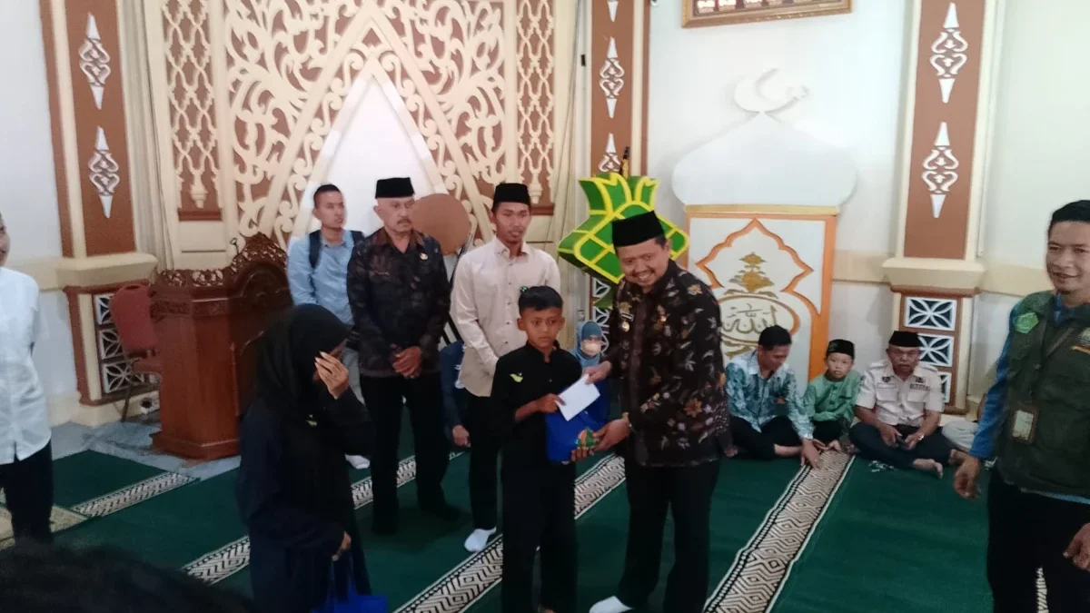 BANTU: Bupati Sumedang, Dony Ahmad Munir saat memberikan santunan kepada salah satu anak yatim di Jatinangor,