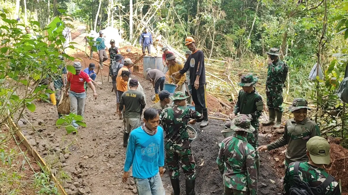 GOTONG ROYONG: Sejumlah personil TNI bersama warga saat pengecoran jalan di Desa Pamulihan Kecamatan, kemarin.
