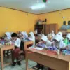 ANTUSIAS: Sejumlah siswa saat menyantap Makan Bergizi Gratis di salah satu sekolah di Kecamatan Tanjungsari, R