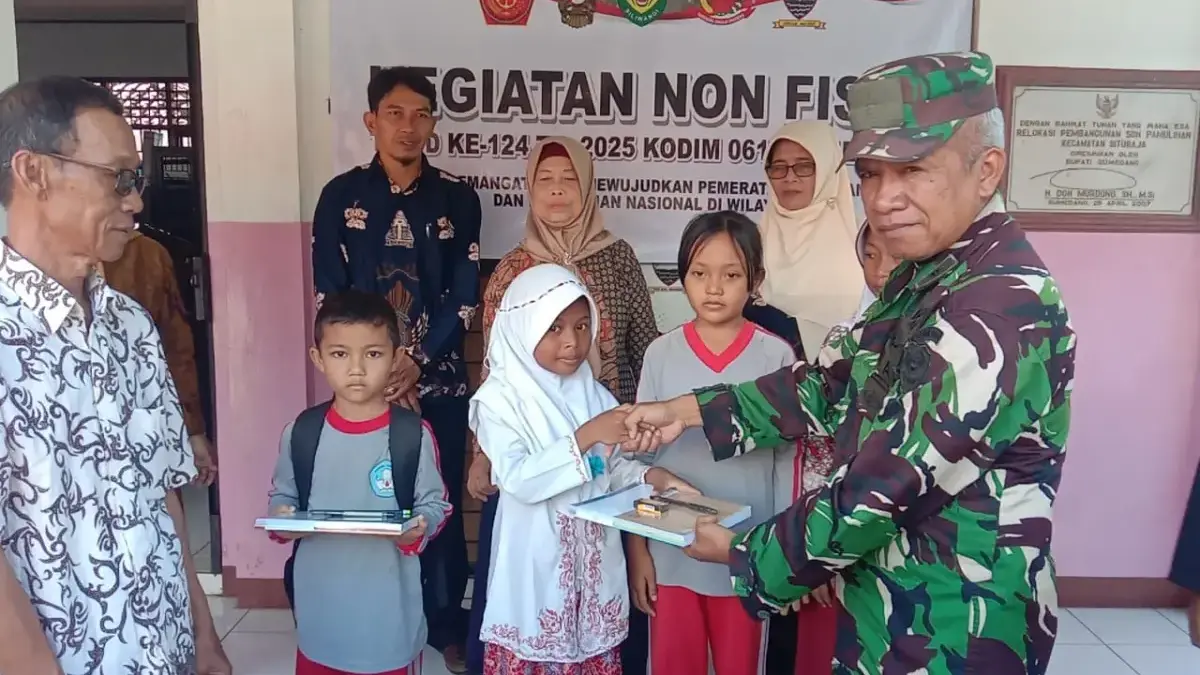 SIMBOLIS: Salah seorang petugas TMMD saat memberikan bantuan alat tulis kepada siswa SDN Pamulihan Kecamatan S