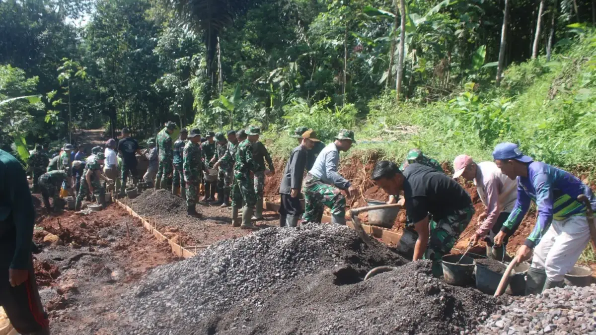 BERSINERGI: Sejumlah personil TNI saat bergotong royong melaksanakan pengecoran jalan di Desa Pamulihan Kecama