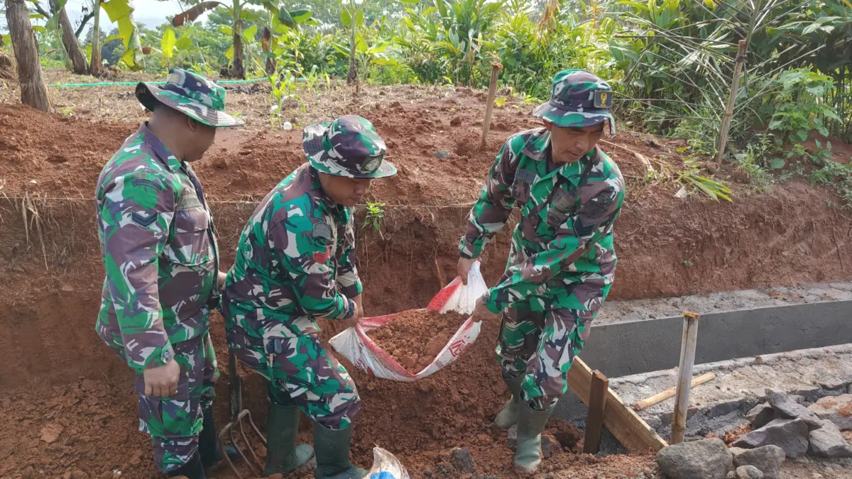 BERSINERGI: Sejumlah personil TNI saat bergotong royong membangung drainase di Desa Pamulihan Kecamatan Situra