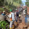 BERSINERGI: Sejumlah warga Petugas Satgas TMMD, dan personil kepolisian saat bergotong-royong melaksanakan pen