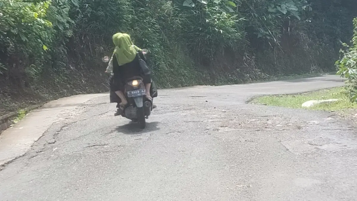 KHAWATIR: Salah satu pengendara saat melintasi jalan berlubang di Desa Kertamekar, Kecamatan Tanjungkerta, kem