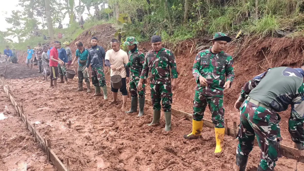 BERSINERGI: Warga bersama petugas Satgas TMMD saat bergotong royong mengecor Jalan di Desa Pamulihan, baru-bar