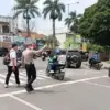 BANTU WARGA: Petugas Polsek Jatinangor, saat melakukan pengaturan lalu lintas serta membantu warga menyebrang