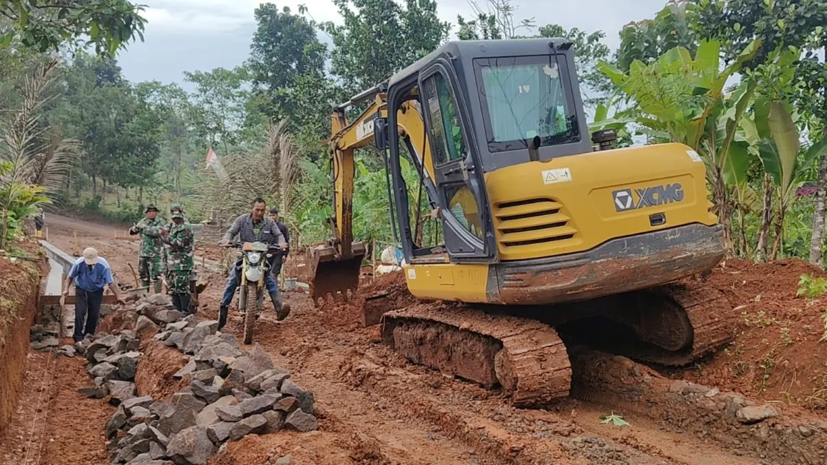 BERSINERGI: Sejumlah petugas Satgas TMMD saat mengerjakan pembangunan drainase di Desa Pamulihan Kecamatan Sit