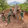 BERSINERGI: Sejumlah warga bersama Satgas TMMD saat bergotong royong mengecor jalan di Desa Pamulihan, kemarin