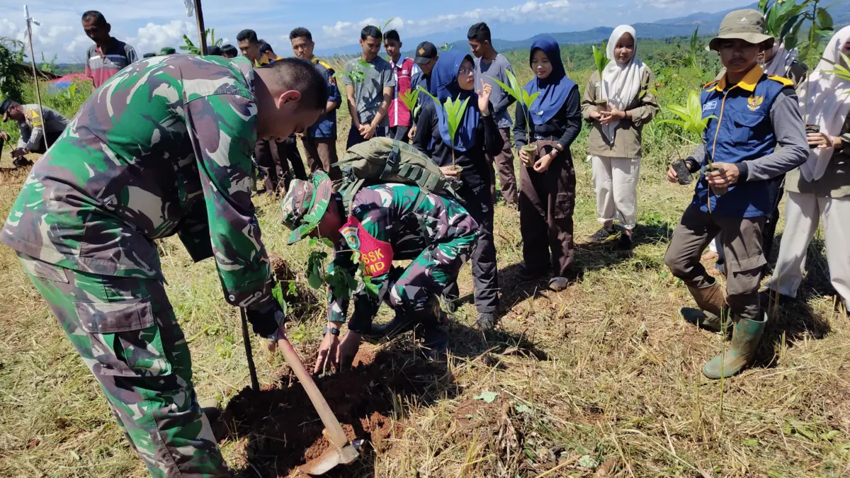 LESTARIKAN: Personil Satgas TMMD bersama pelajar saat pelaksanaan kegiatan penanaman pohon di Kecamatan Situra