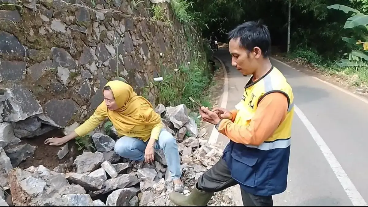Sebuah tebing penahan tanah (TPT) roboh akibat hujan deras, menutup sebagian jalan utama kabupaten Sumedang da