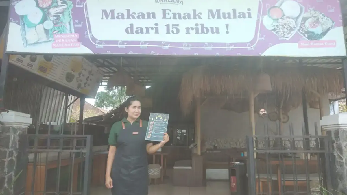 MELAYANI: Chef Restoran Ayam Wijen Khalana, Dewi tengah penyambut konsumen yang akan mengunjungi restorannya.(