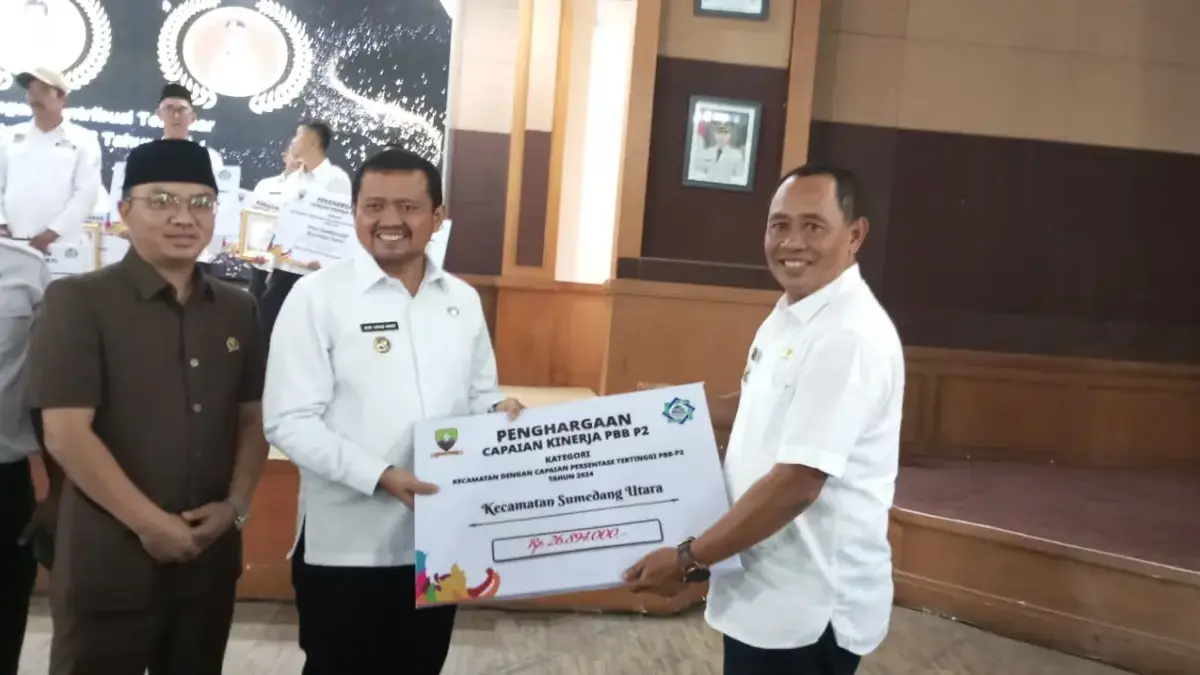 TEGAS: Bupati Sumedang Dony Ahmad Munir menyerahkan penghargaan kepada Camat Sumedang utara, Ayuh Hidayat, ata