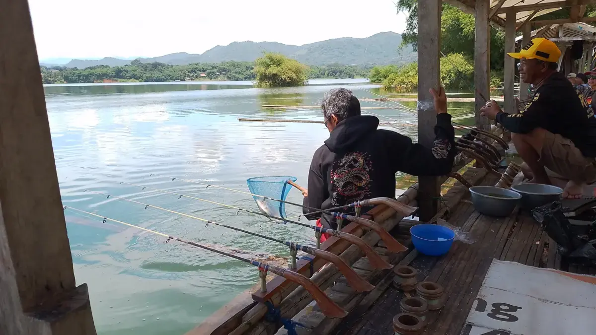 Salah satu pemancing sedang membantu mengangkat ikan yang didapatkan oleh rekannya. (Eksus/Sumeks)