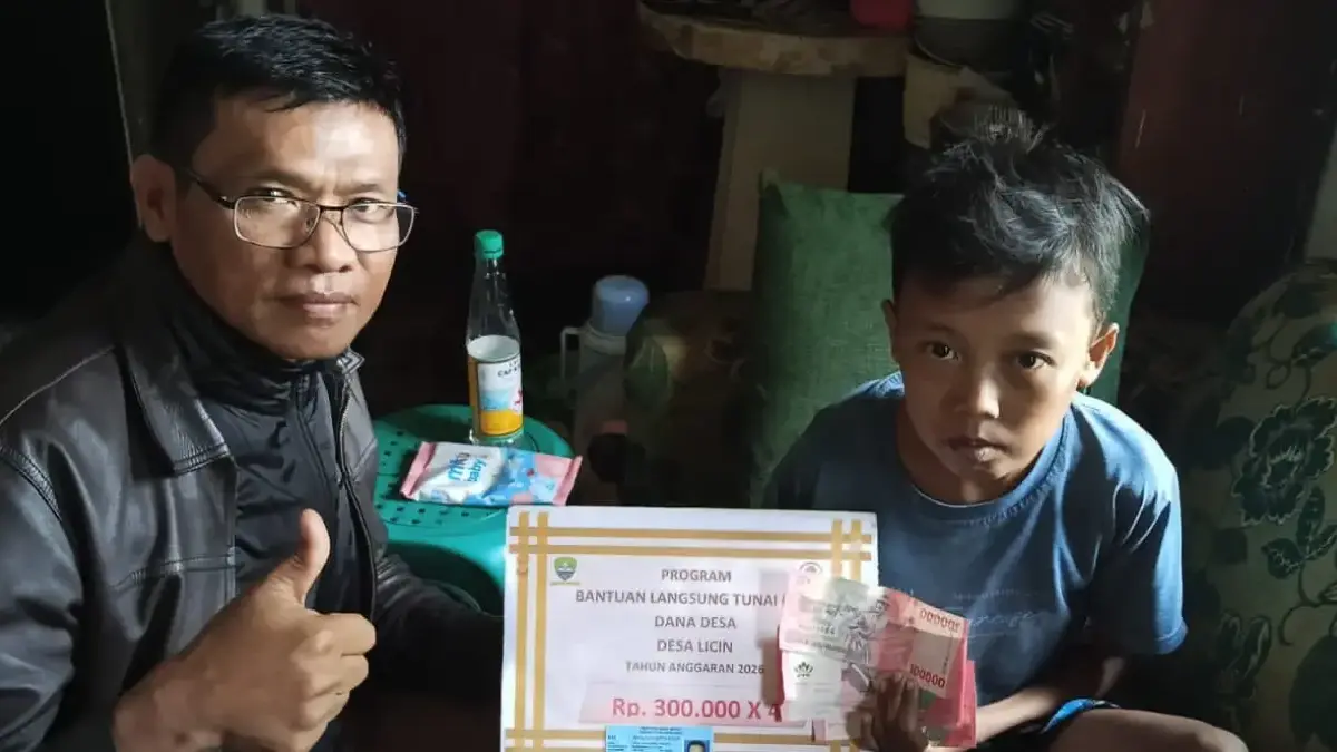 Kepala Desa Licin, Zulkifli M Ridwan, saat menyerahkan BLT Pada salah seorang KPM dengan jemput bola mendatang