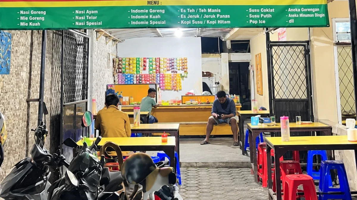Suasana Warung Makan Motekar 5 pada malam hari dengan meja makan, kursi plastik,